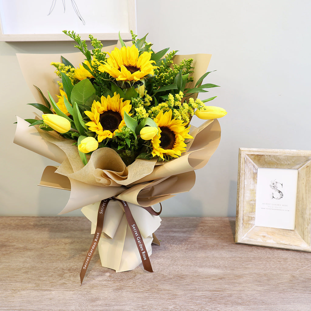 Bouquet of Sunflowers, Tulips, and Solidagos with Lemon Leaves and Ruscus greeneries.