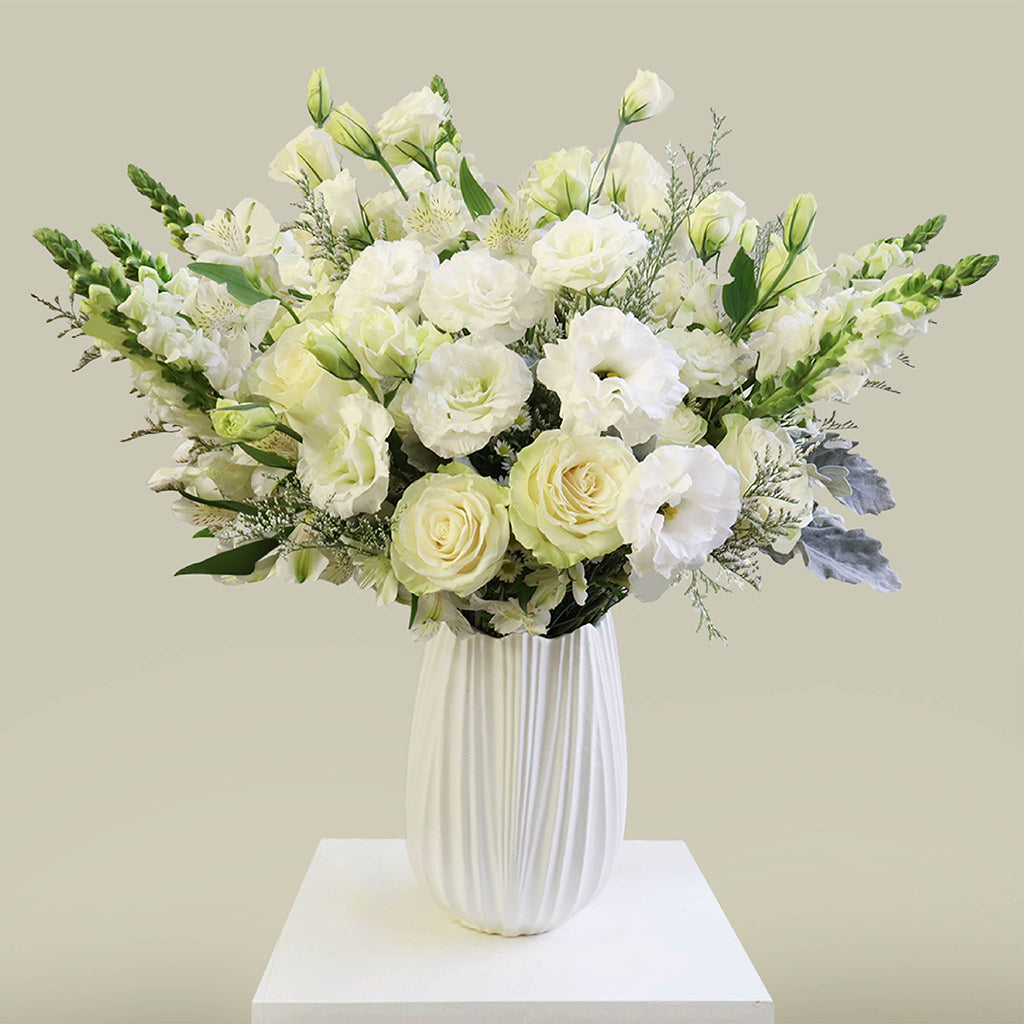 Bundle of Vendela Roses, Alstroemeria Whistler, Caspia, White Lisianthus, White Aster, Bupleurum and snapdragons with Dusty Miller greeneries.
