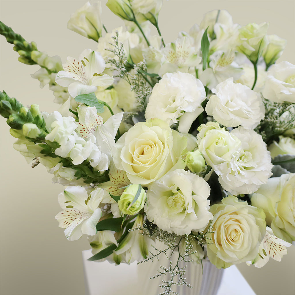 Bundle of Vendela Roses, Alstroemeria Whistler, Caspia, White Lisianthus, White Aster, Bupleurum and snapdragons with Dusty Miller greeneries.