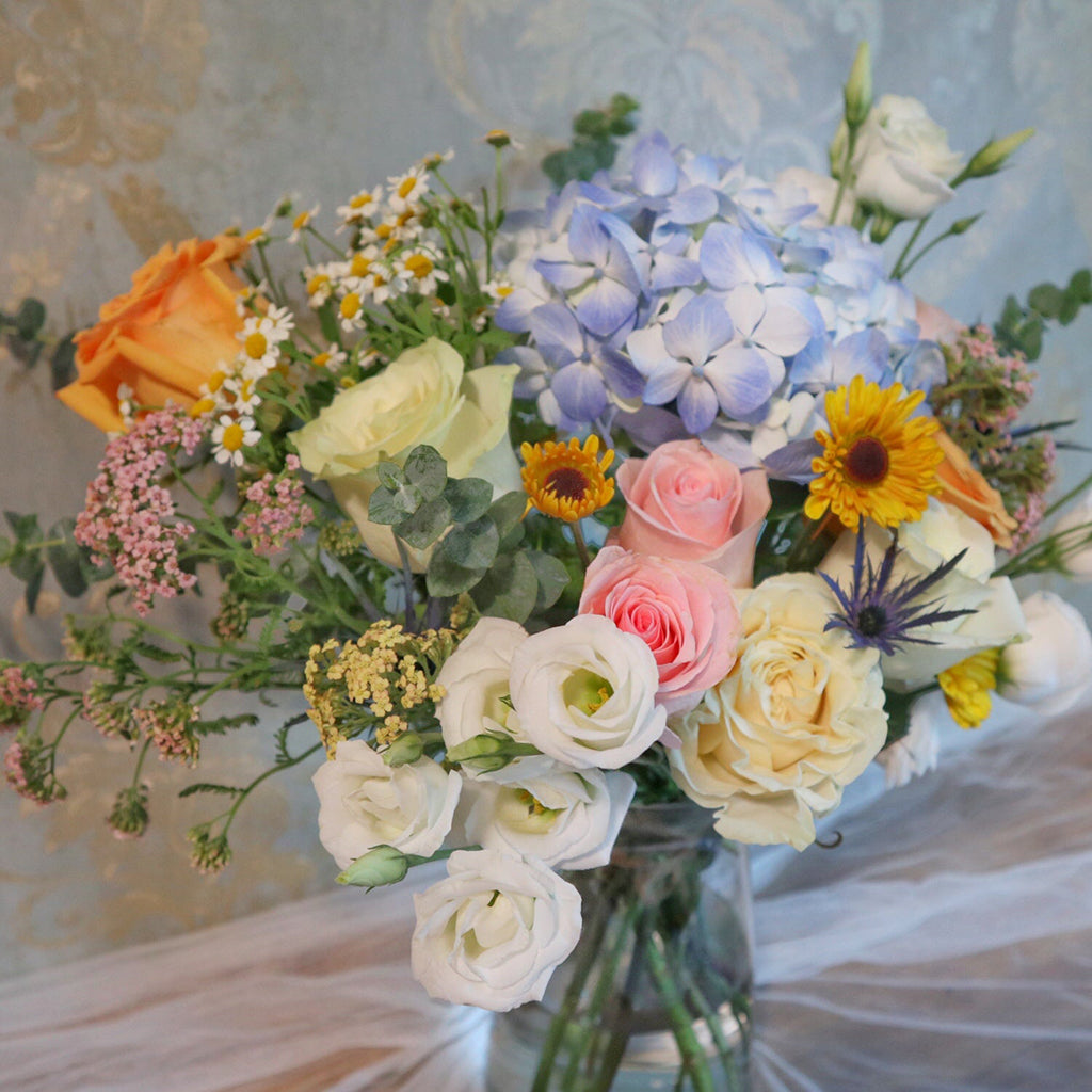 Bundle of Roses, Lisianthus, Pomp Daisies, and Blue Hydrangeas with Eucalyptus greeneries.