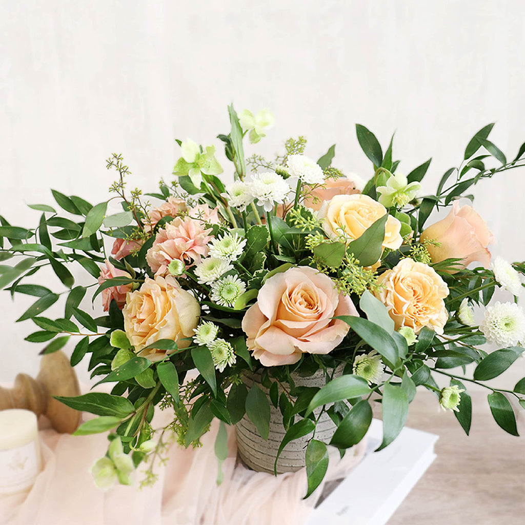 Bouquet of Pearl Roses, Shimmer Roses, Carnations, Hellebores, and White Pompoms with Seeded Eucalyptus and Ruscus greeneries.