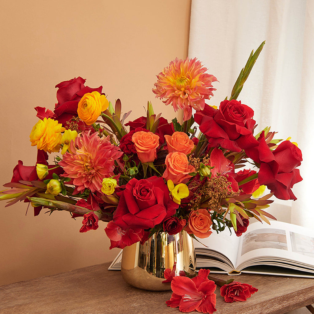Bouquet of Freedom Roses, Orange Ranunculus, Yellow Ranunculus, Orange Spray Roses, Orange Dahlia, Red Gladiolus, Leucadendron, and Celosia.