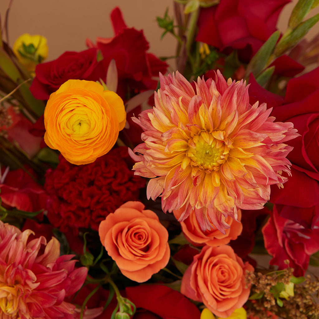 Bouquet of Freedom Roses, Orange Ranunculus, Yellow Ranunculus, Orange Spray Roses, Orange Dahlia, Red Gladiolus, Leucadendron, and Celosia.